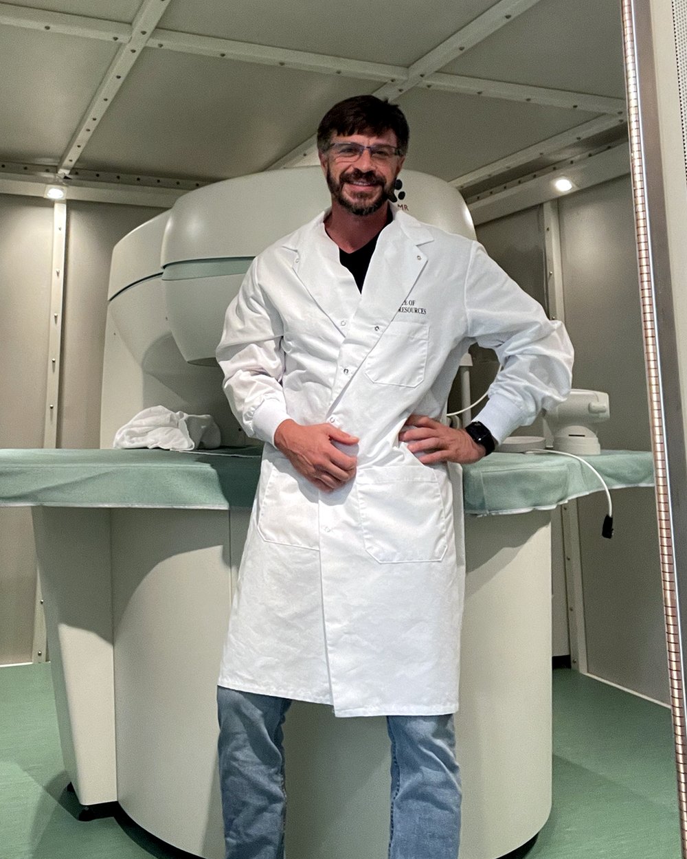 Leonid Strugatsky in a lab coat beside a permanent-magnet MRI inside a shielded room